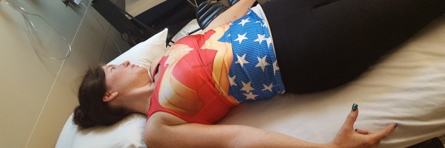 woman lying on doctor table with superman style shirt
