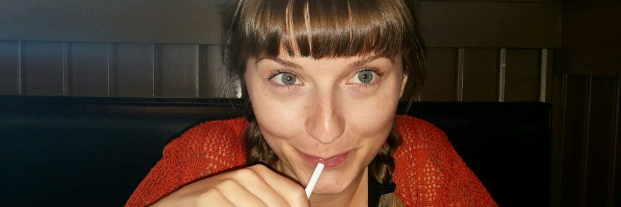 What I Didn't Know Would Happen When I Became Chronically Ill woman sitting at a table drinking through a straw