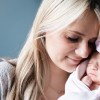 professional photo of woman with newborn baby wearing pink bow