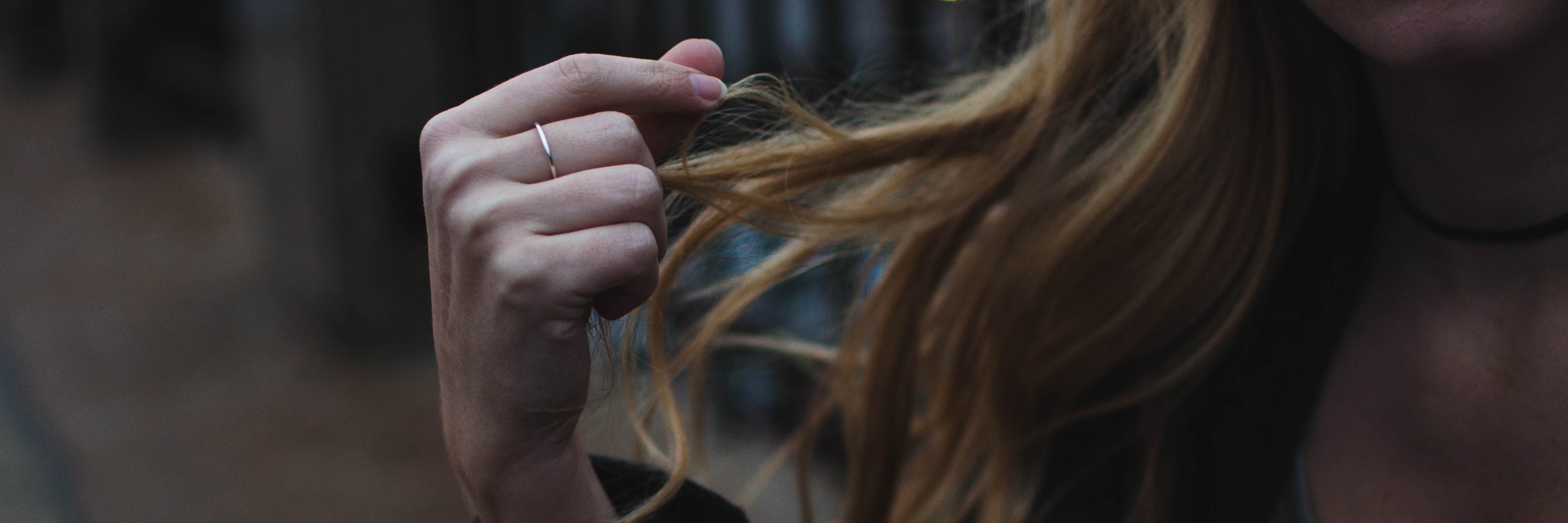 blonde woman playing with hair in anxious manner