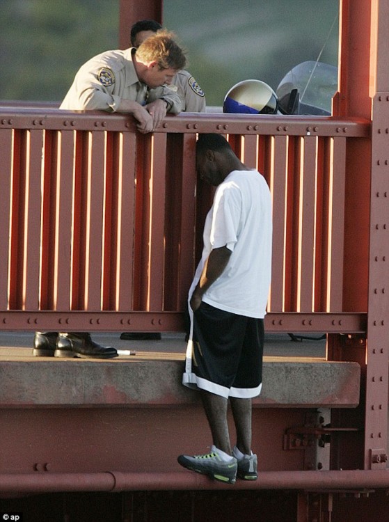 Highway Patrol Sergeant Kevin Briggs listens to Grateful Berthia as he stands on the edge of the Golden Gate Bridge