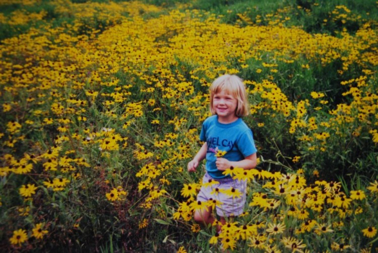 young girl in field of yellow flowers