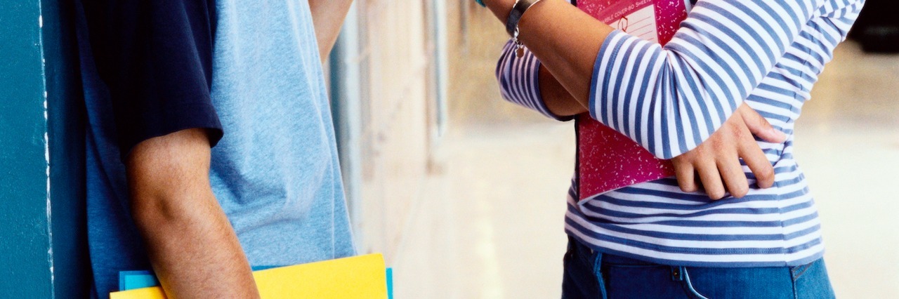 The First Time I Met Someone Else With Type 1 Diabetes Teenage Boy and Girl Stand Face to Face By Lockers in a Secondary School Corridor