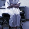 woman sitting on exam table at hospital wearing hospital gown