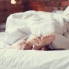 couple's feet under blanket