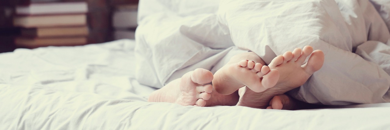 What It Was Like Having Sex After Chemotherapy couple's feet under blanket
