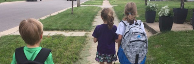 three kids walking to school