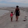 The author and her daughter walking on the beach