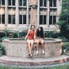 The author with a friend, sitting on the edge of a fountain in front of a building