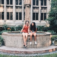 The author with a friend, sitting on the edge of a fountain in front of a building