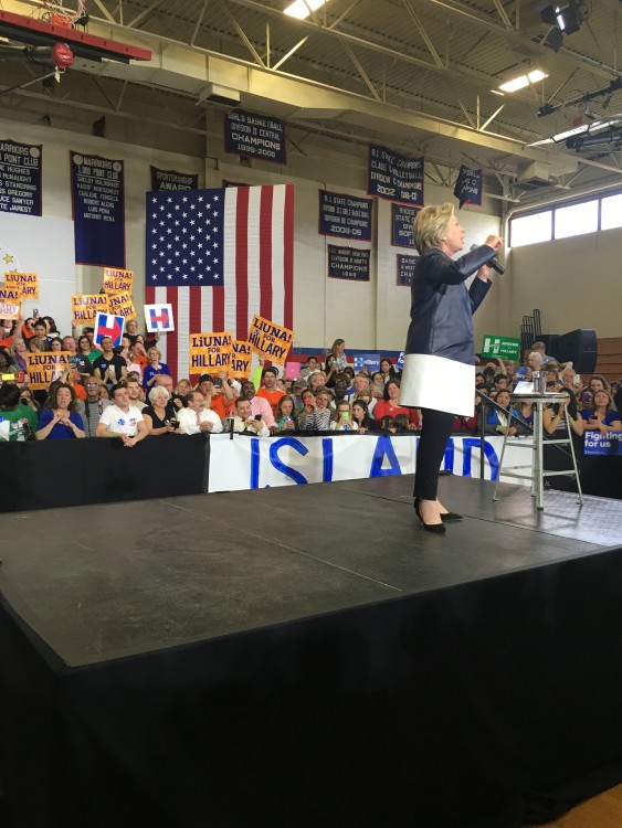 At this Hillary Clinton rally, the interpreter was forced to stand behind the barrier, making her difficult to see and creating a potentially unsafe situation for her. (Interpreter is on the left, wearing a blue dress.)