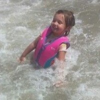 little girl in ocean waves playing
