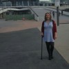 woman standing outside arena with a cane