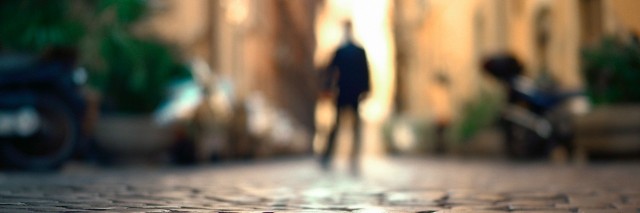 Blurry man standing on cobblestone street