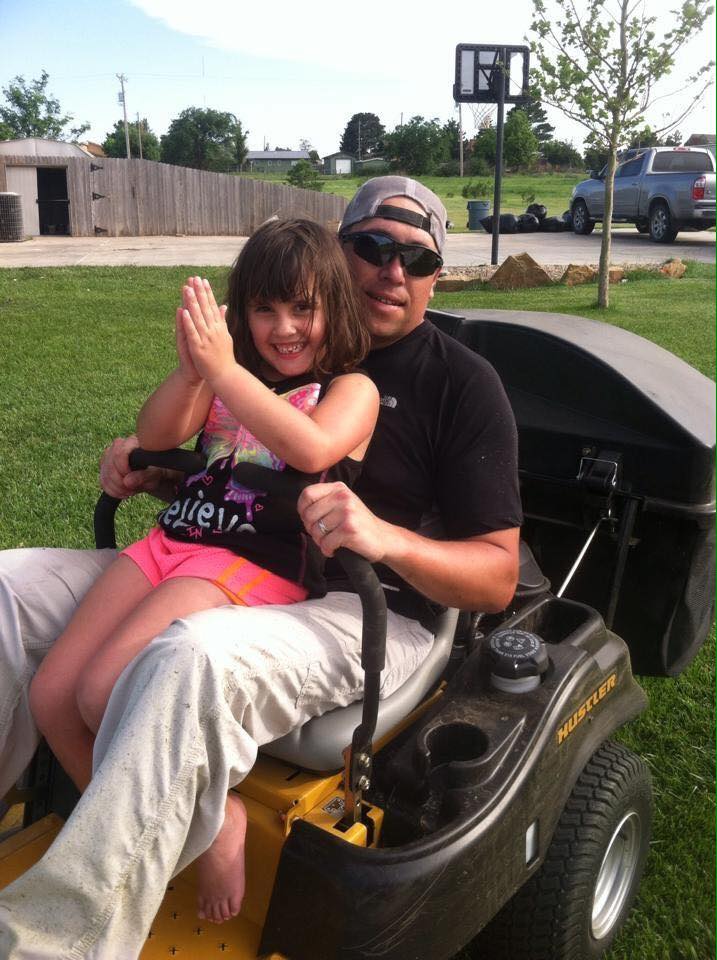 daughter mowing the lawn with daddy