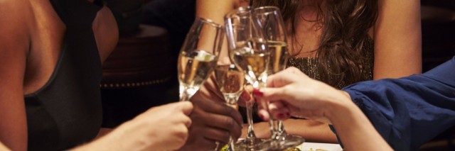 Group Of Female Friends Enjoying Meal In Restaurant and toasting glasses