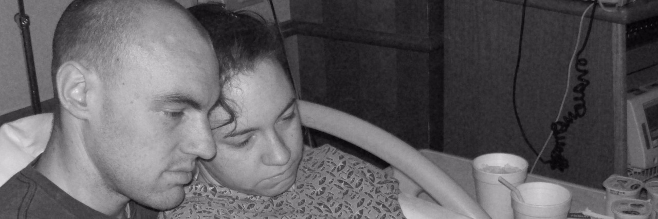 Grieving About Breast Milk After a Miscarriage man and woman in hospital bed holding baby