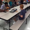boy and football play sit at lunch table