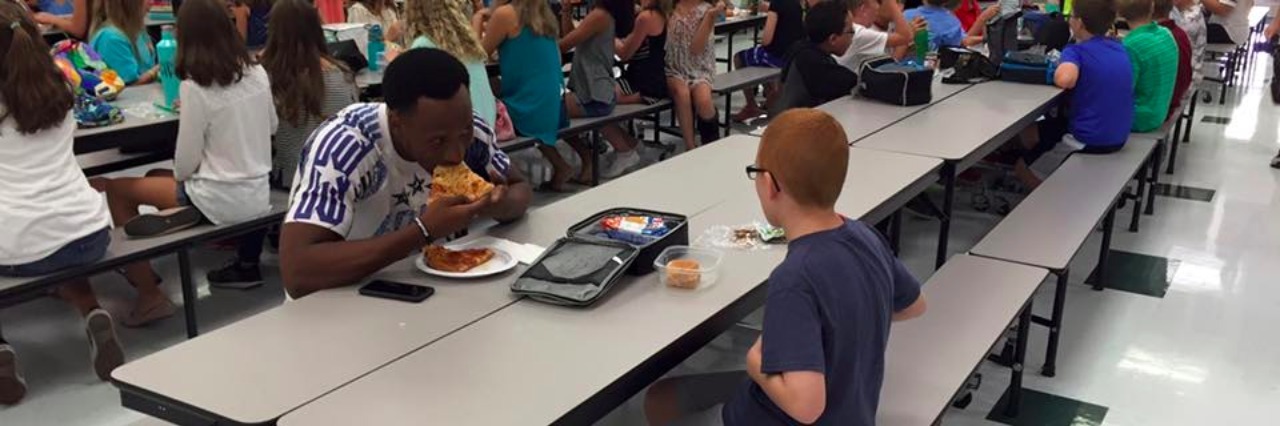 boy and football play sit at lunch table