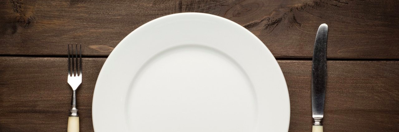 Woman Asks for Understanding If an Autistic Person Is a ‘Fussy Eater’ plate and silverware on a wooden table