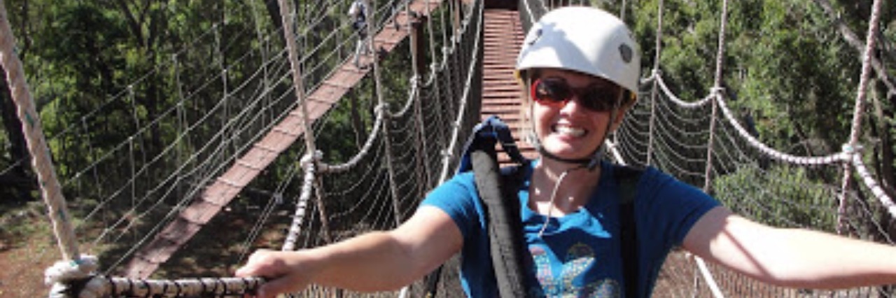 Accepting What I Can't Do With POTS woman standing on swinging bridge wearing helmet