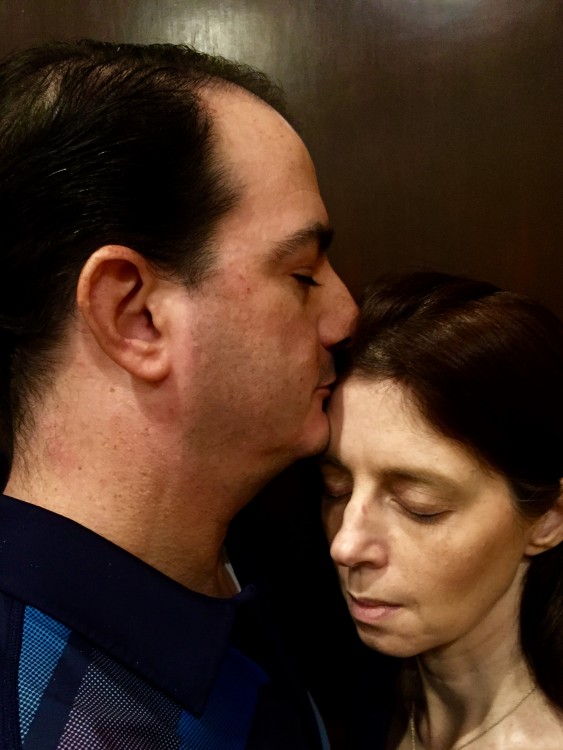 husband kissing his wife on the forehead