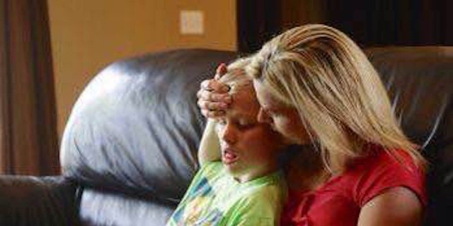 All Parents of Children With Epilepsy Should Be Warned About SUDEP boy sitting on mom's lap