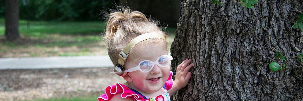 Hearing 'I'm Sorry' As a Special Needs Parent Ashlyn near a tree outside smiling.