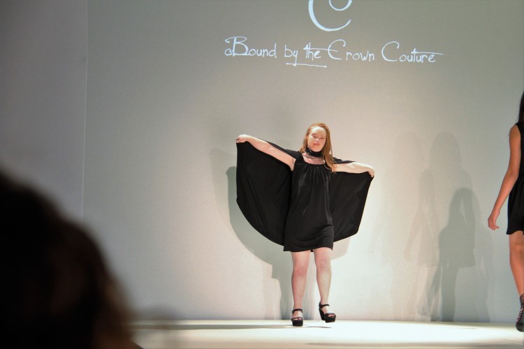 Madeline Stuart on the runway with her cape open