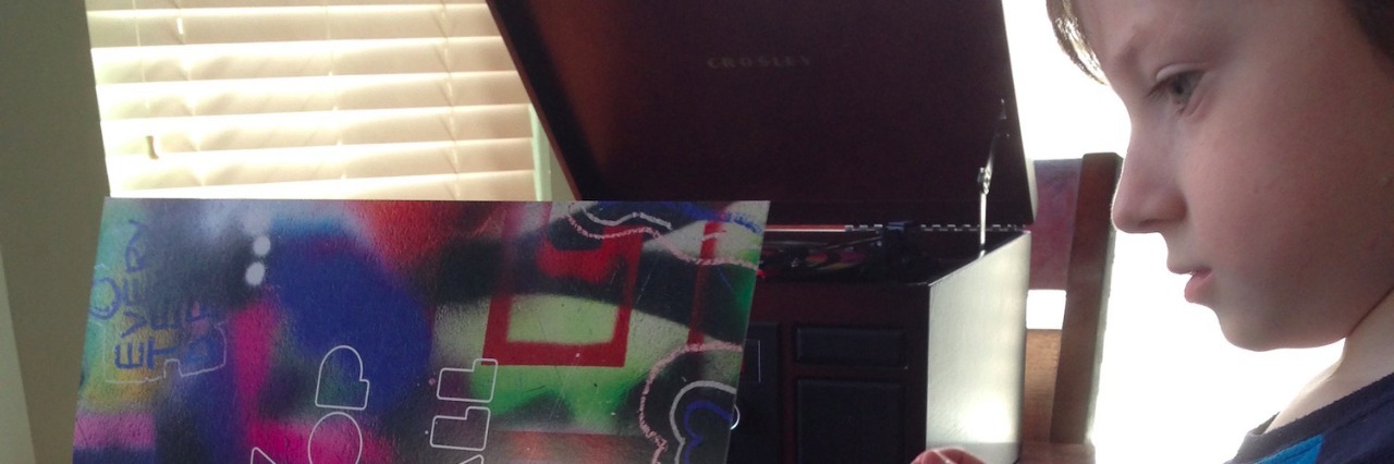 Connecting With My Son on the Autism Spectrum Through Coldplay The author's son looking at a Coldplay book