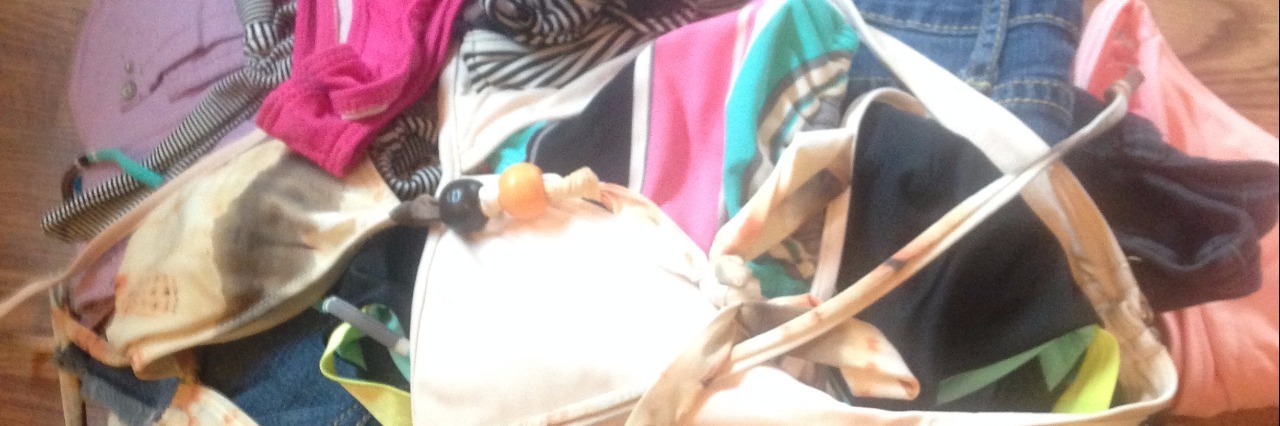 Turning Down the Volume of My Eating Disorder's Voice in the Summer Pile of women's swimsuits on a wood floor