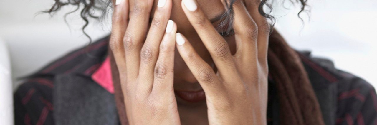 Travel Tips for People With Migraines woman with hands over her face