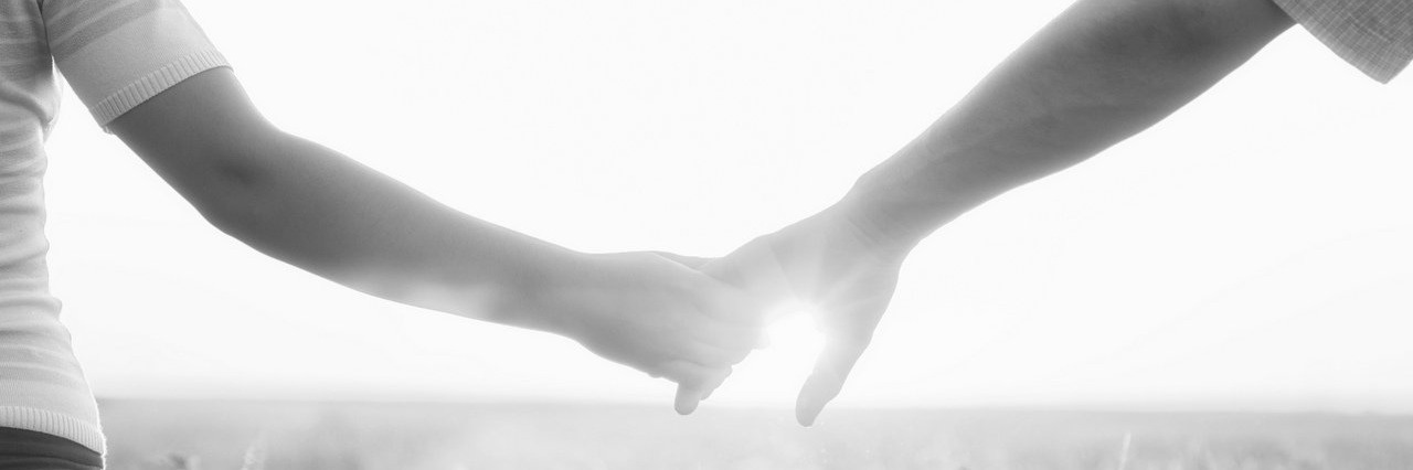 Reasons I Am Grateful for My Partner When It Comes to My Illnesses young couple holding hands in a field