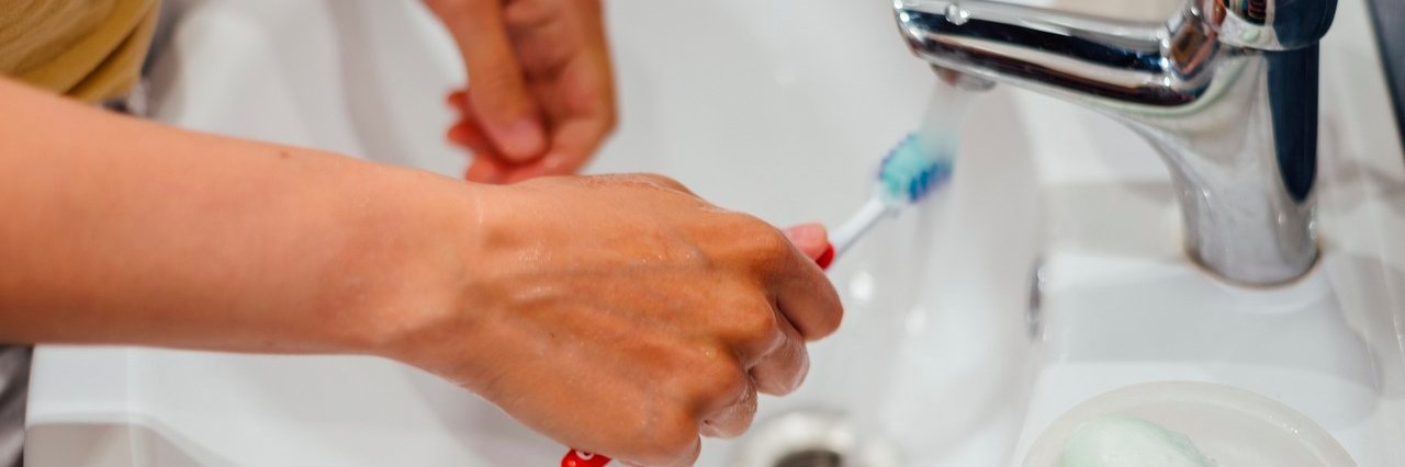 Chronic Pain Makes My Morning Routine a Big Deal woman brushing her teeth
