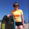 woman on a beach holding a bodyboard