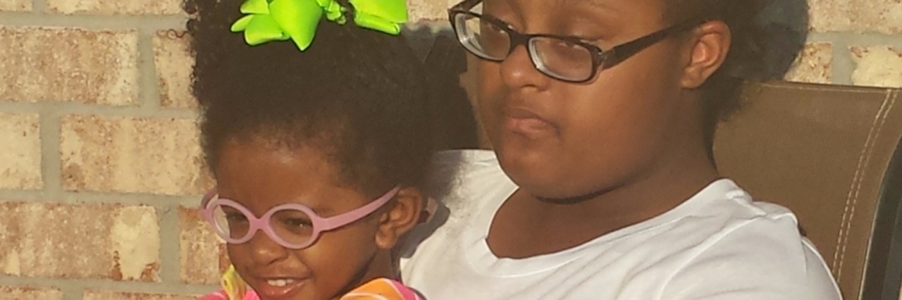 Mom's Letter to Little Sister of Daughter With Down Syndrome big and little sister hugging