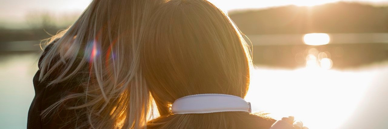 Woman With Occipital Neuralgia Thanks Friend for Sticking by Her two women watch the sunset by a lake