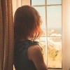 young woman looking out a window
