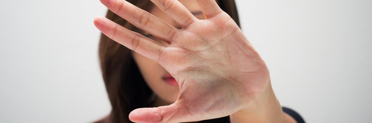 Goodbye Letter to Anorexia woman holds hand straight in front of face