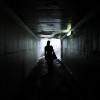 woman walking out of a dark tunnel
