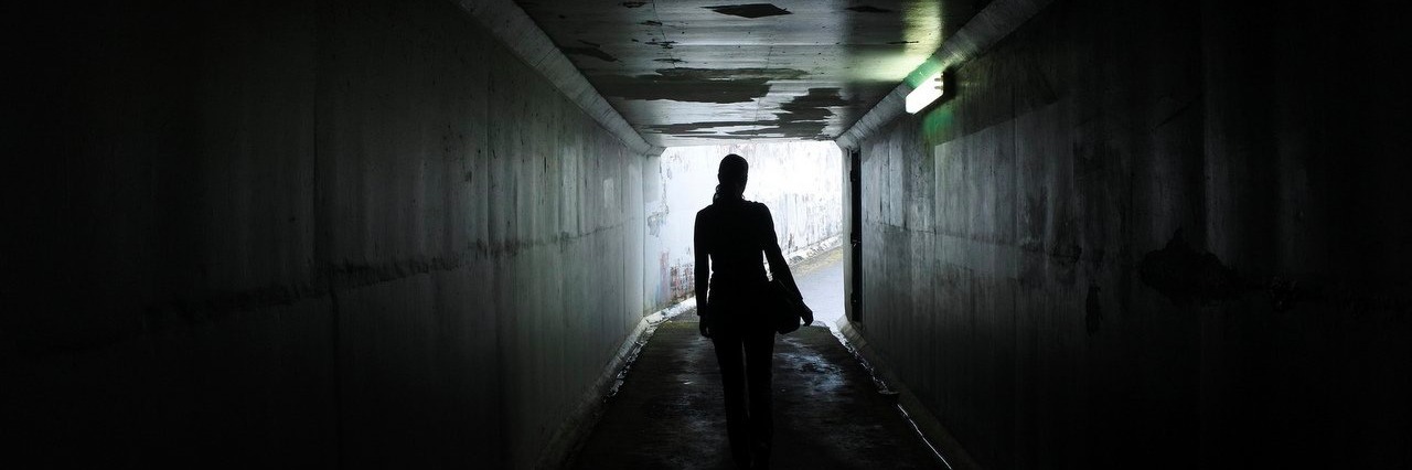 I’m Worried My Endometriosis Is Coming Back woman walking out of a dark tunnel