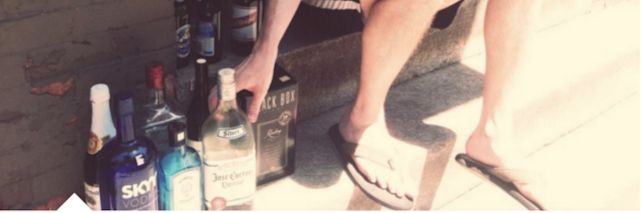 Accepting My Alcoholism: Why I Stopped Drinking man surrounded by bottles of alcohol