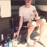 man surrounded by bottles of alcohol
