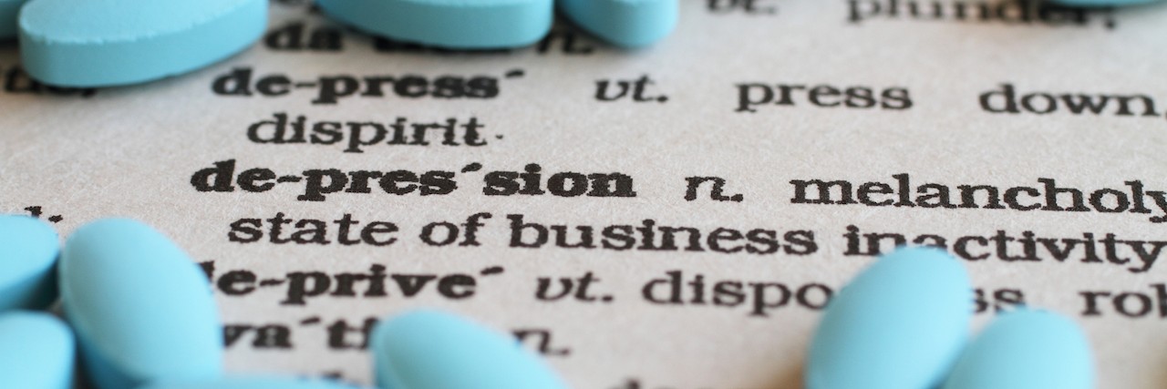 How to Practice Self-Care After Starting Antidepressants A close up image of the word "Depression" surrounded by pills.