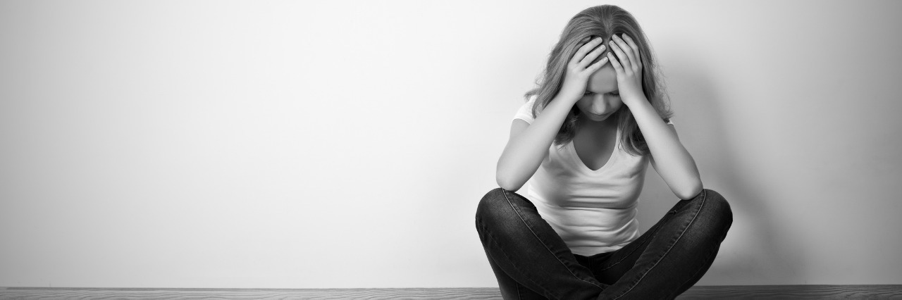 What I Remember on Hard Days With Depression and Migraine girl sitting on floor with head in hands