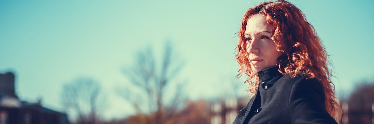 Why You Shouldn't Say 'Suicide Is Selfish' woman leaning against a railing outside
