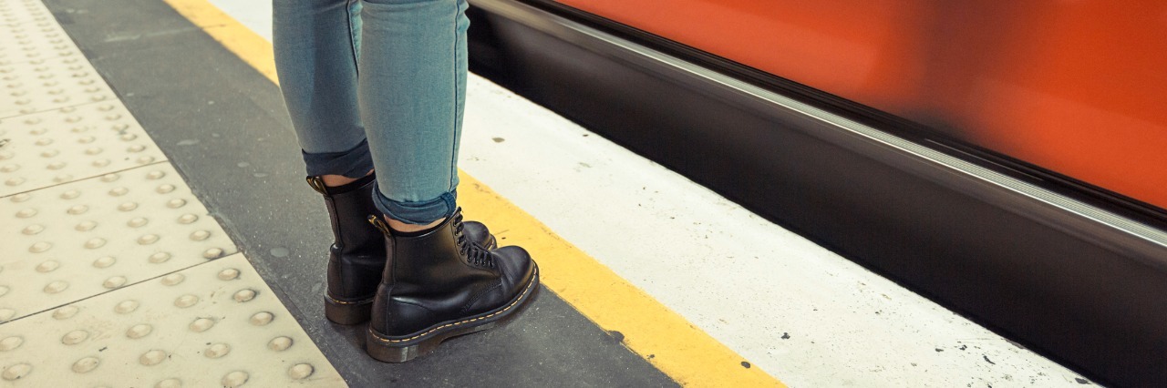 woman wearing boots waiting for metro train