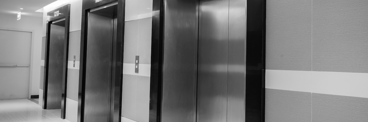 black and white photo of three elevators side by side