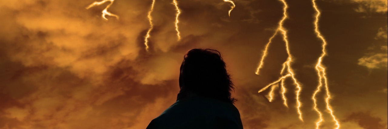 Receiving Multiple Rare Diagnoses for Your Children a lone woman looking sadly over the cliffs edge in county clare ireland during a thunder storm