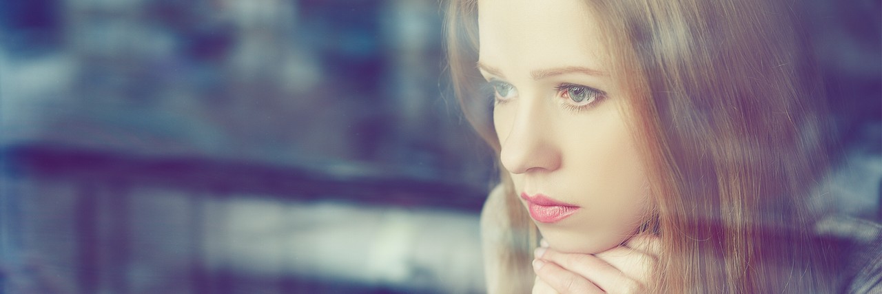 Tips for Living With Mental Illness sad girl looking out a window